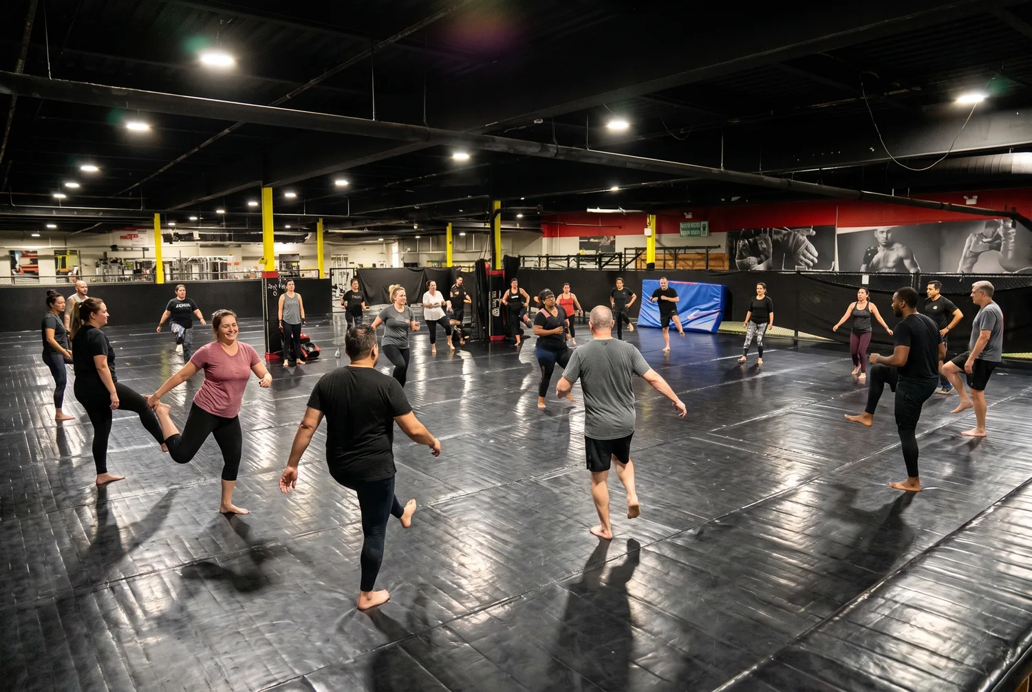 Adult beginners doing a warm-up together on the mats at Xtreme Couture