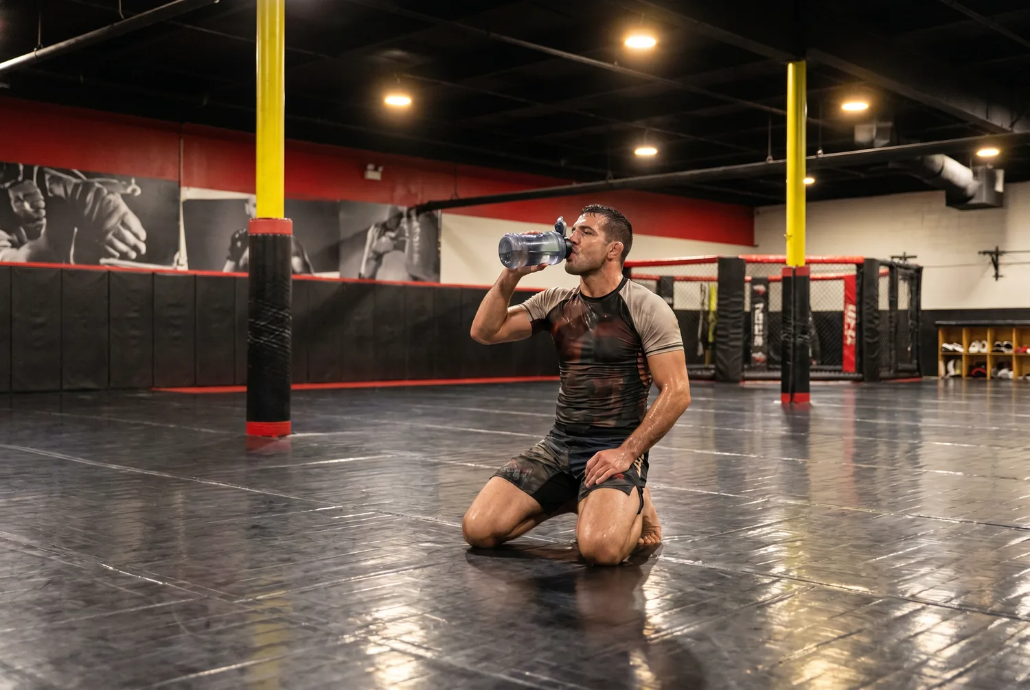 An athlete pausing to drink water during training at Xtreme Couture